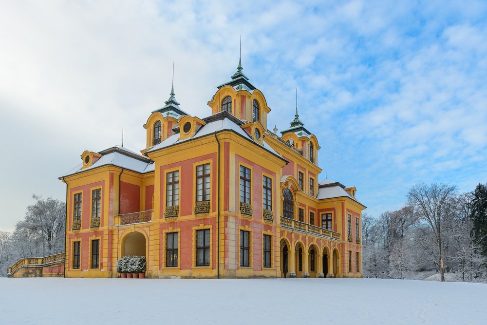 Foto von Schloss Favorite in Winterlandschaft mit Schnee und blauem Himmel